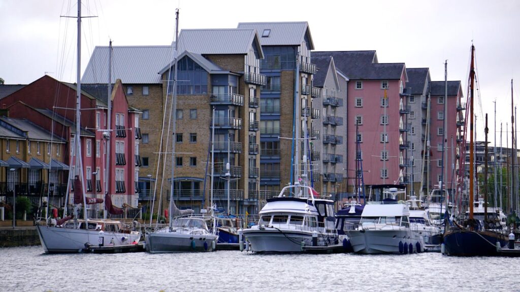 Waterfront view of modern apartments and yachts in a scenic marina.