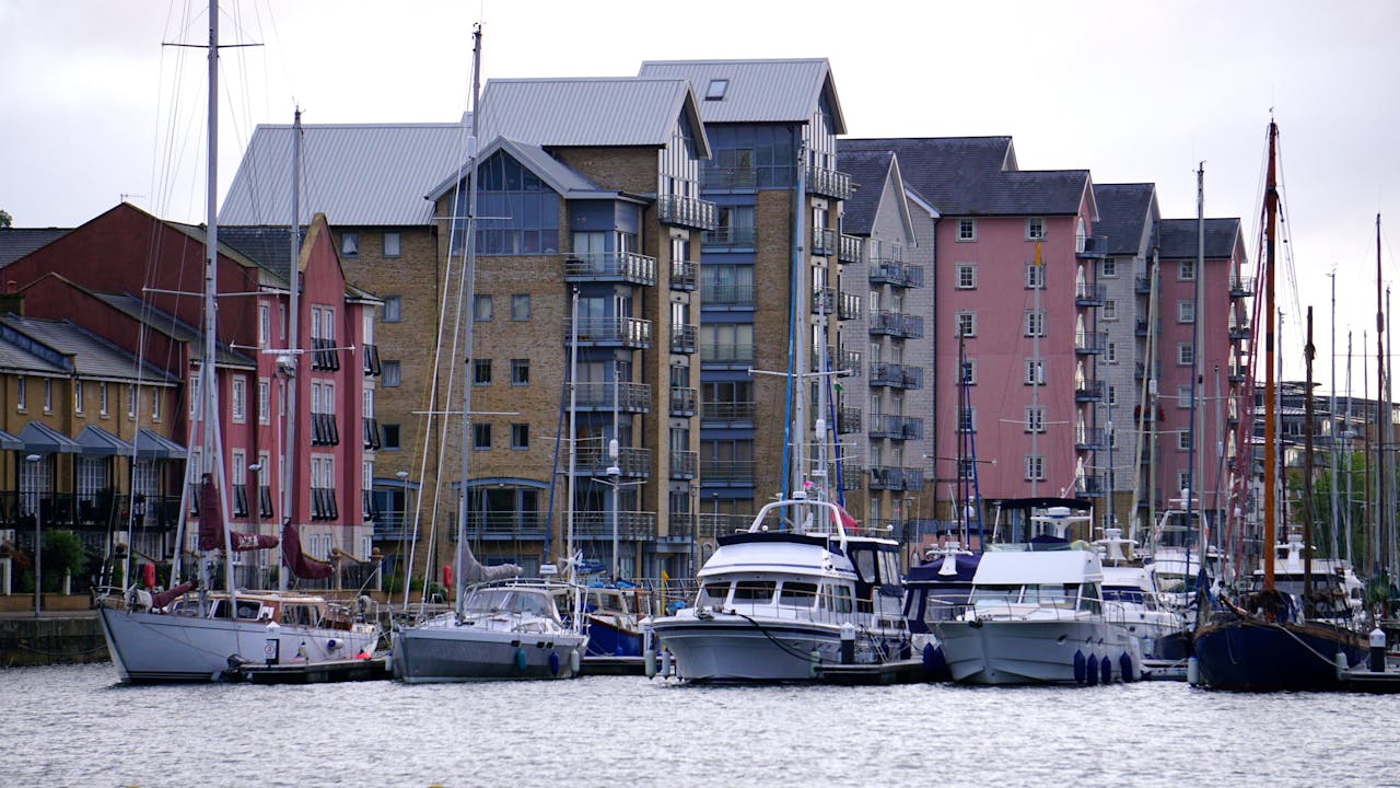 Waterfront view of modern apartments and yachts in a scenic marina.